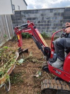 Mini digger preparing ground for patio installation in Ireland